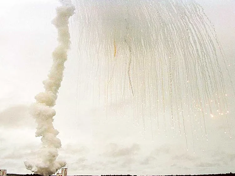 Le scie dei frammenti di Ariane 5 nel cielo di Kourou, accanto alla colonna di fumo del decollo